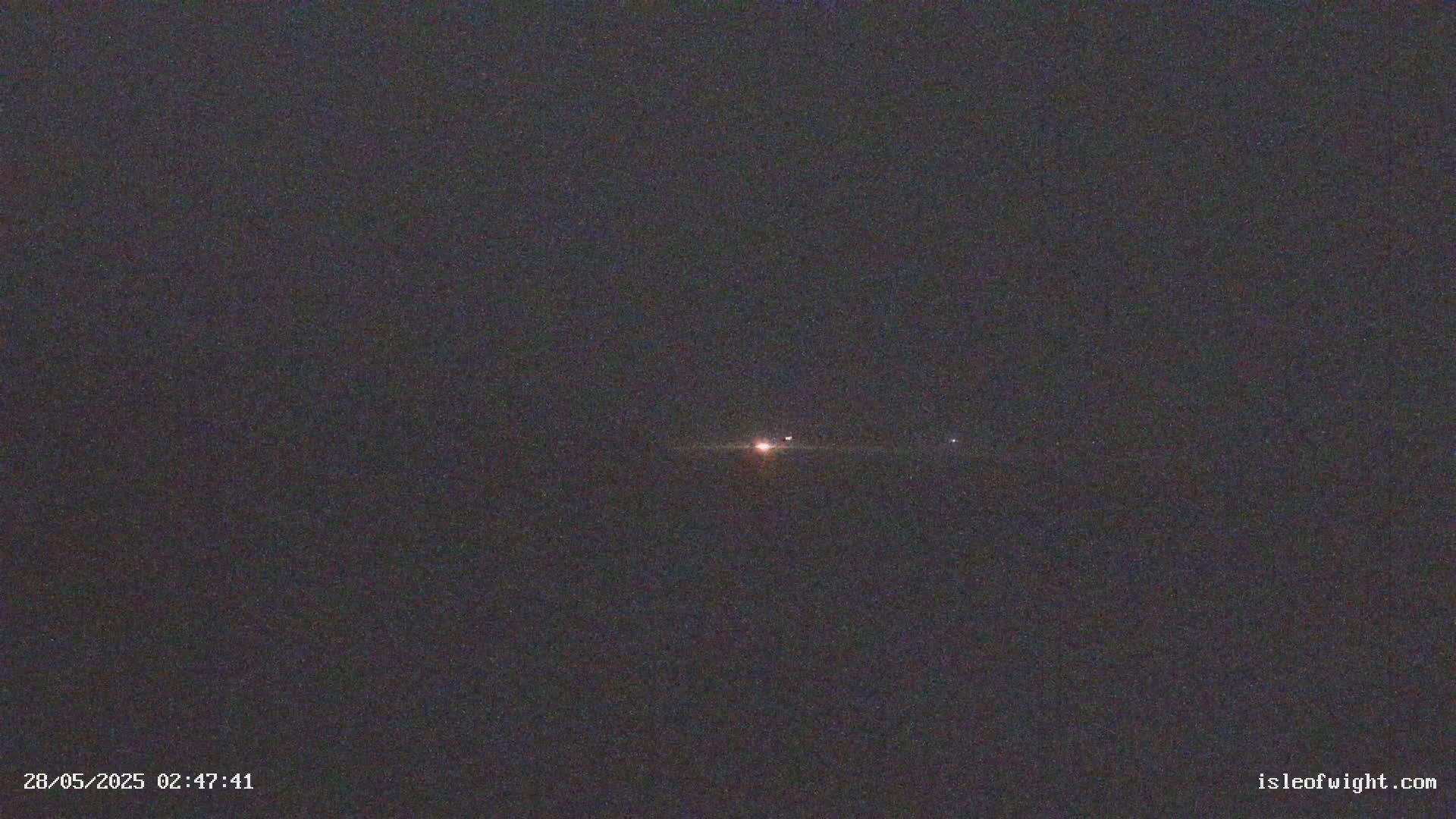 A nighttime long exposure shows a bright star with fainter objects to either side.