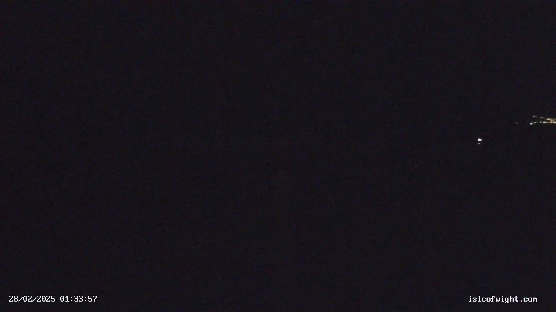 A dark, nighttime scene shows a few distant, faint lights.