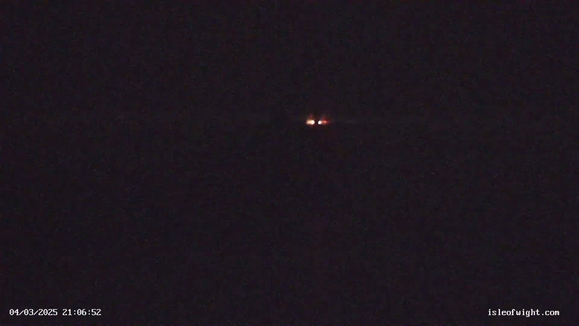 Two faint orange lights are visible in the dark night sky.