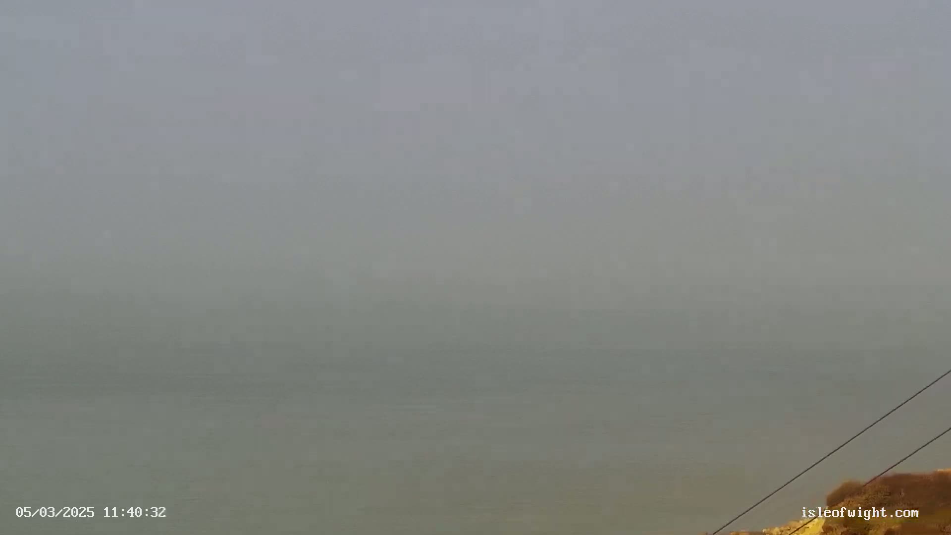 A foggy, hazy view of a body of water extends to the horizon.