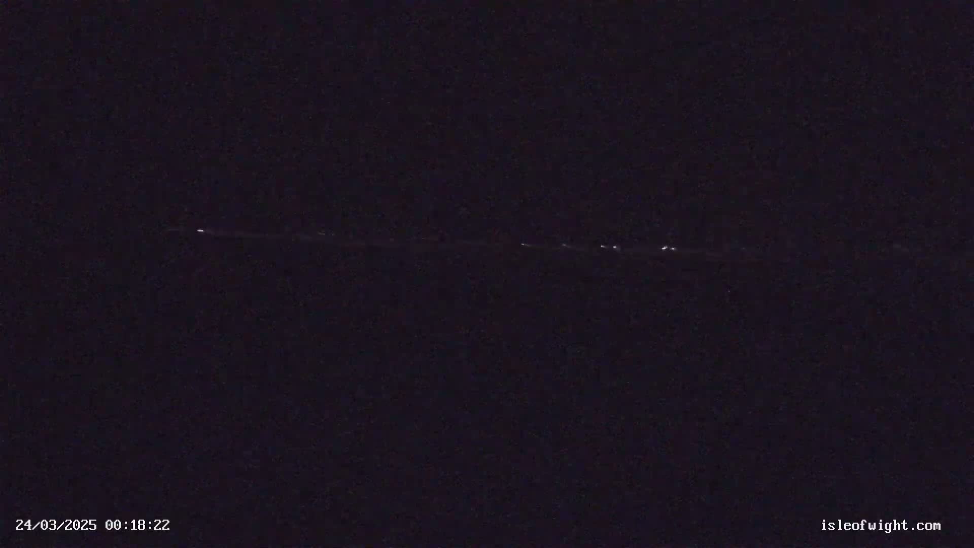 A long, thin line of faint lights is visible in the night sky.