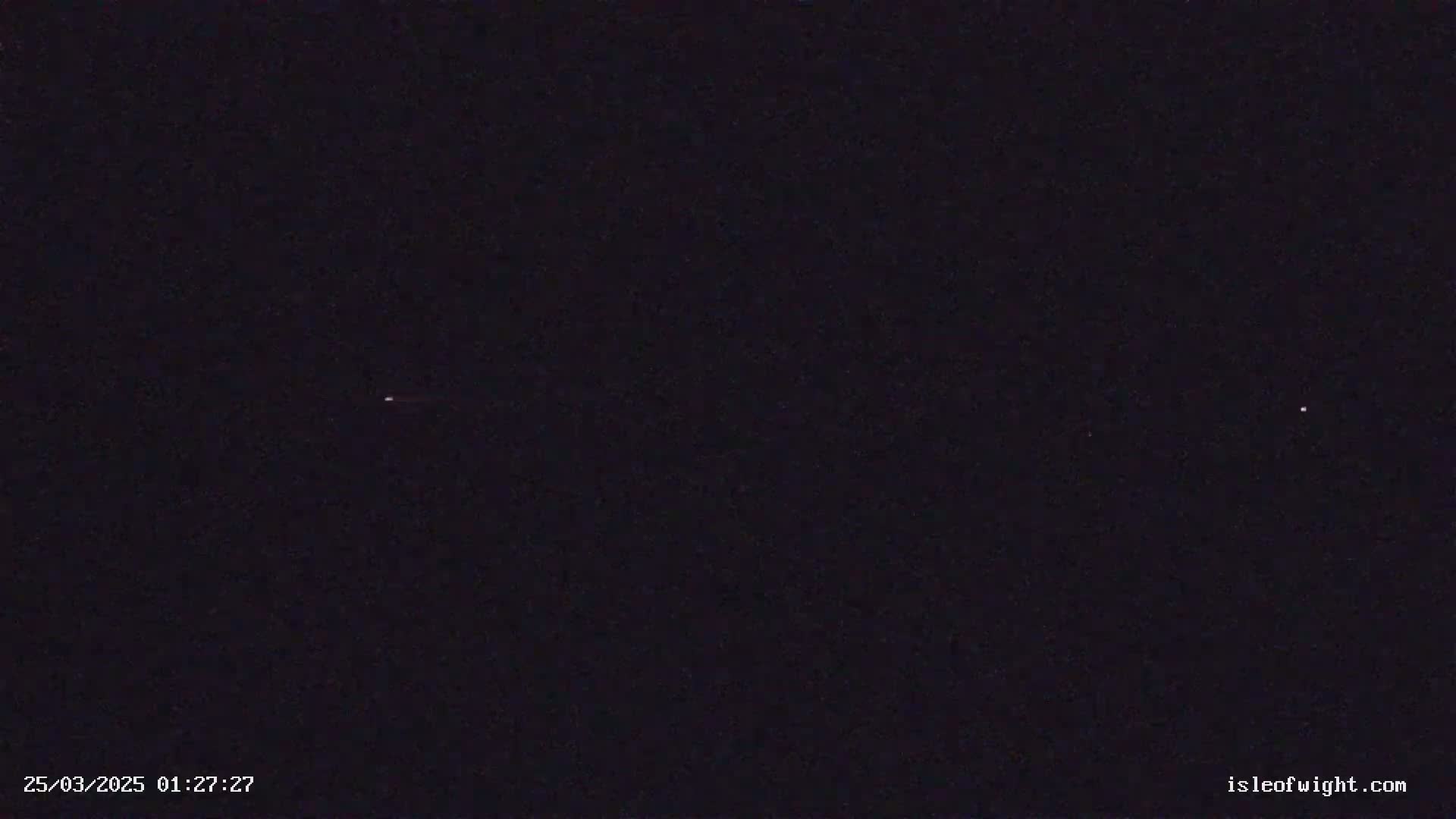 A dark nighttime sky shows two faint points of light.