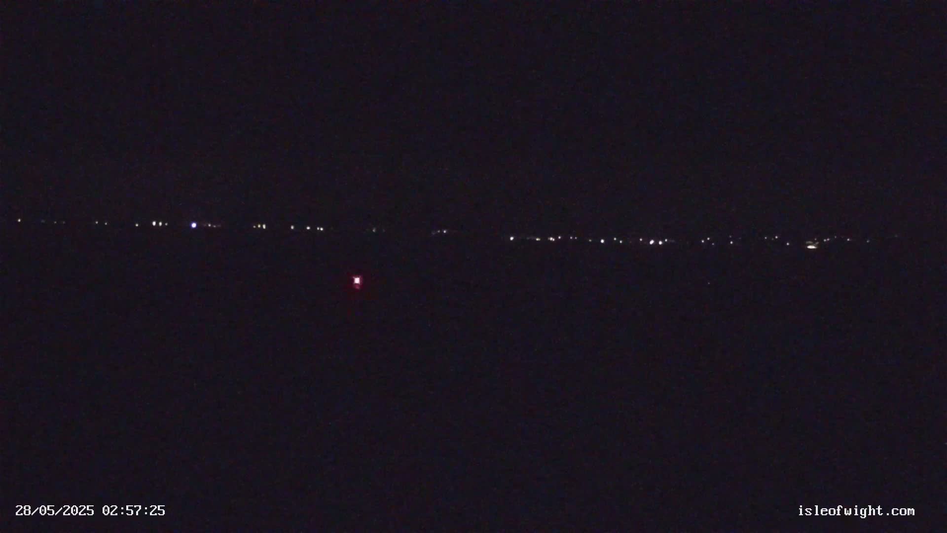 A distant line of lights is visible on a dark, nighttime landscape.