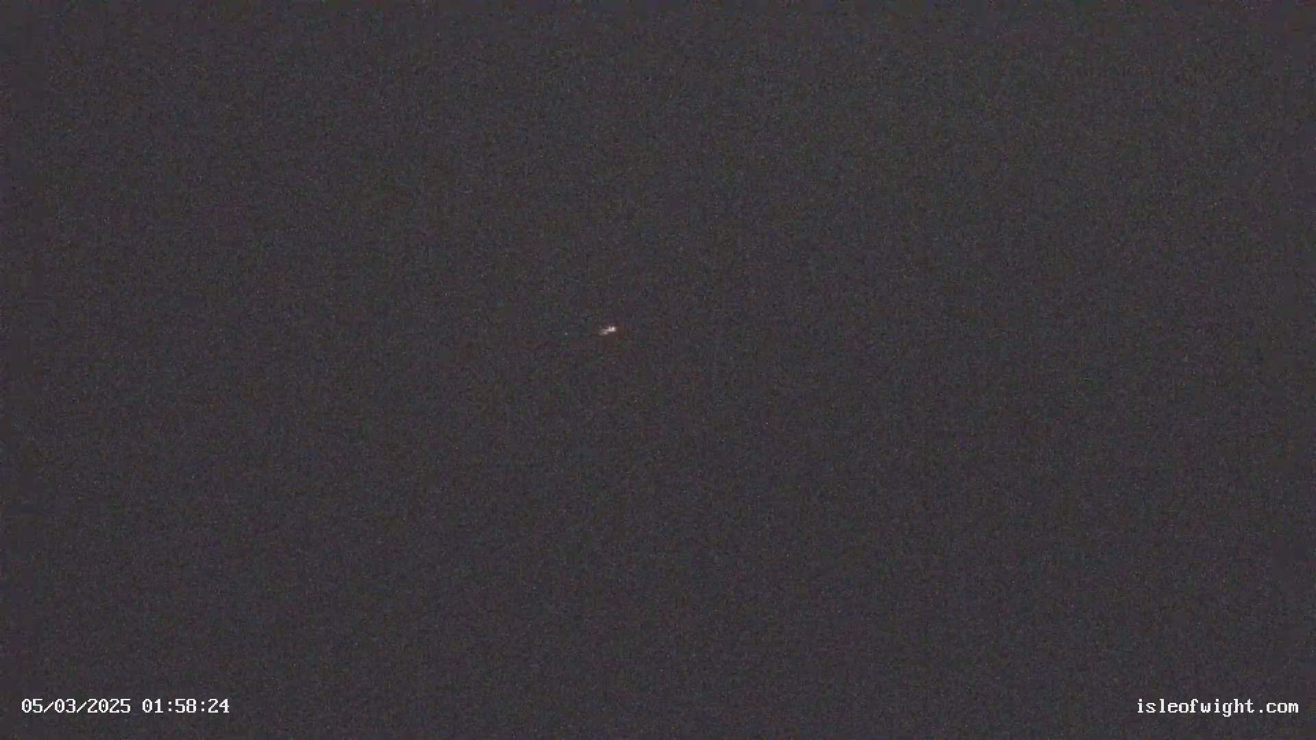 A tiny, faint light is visible in a dark, nighttime sky.