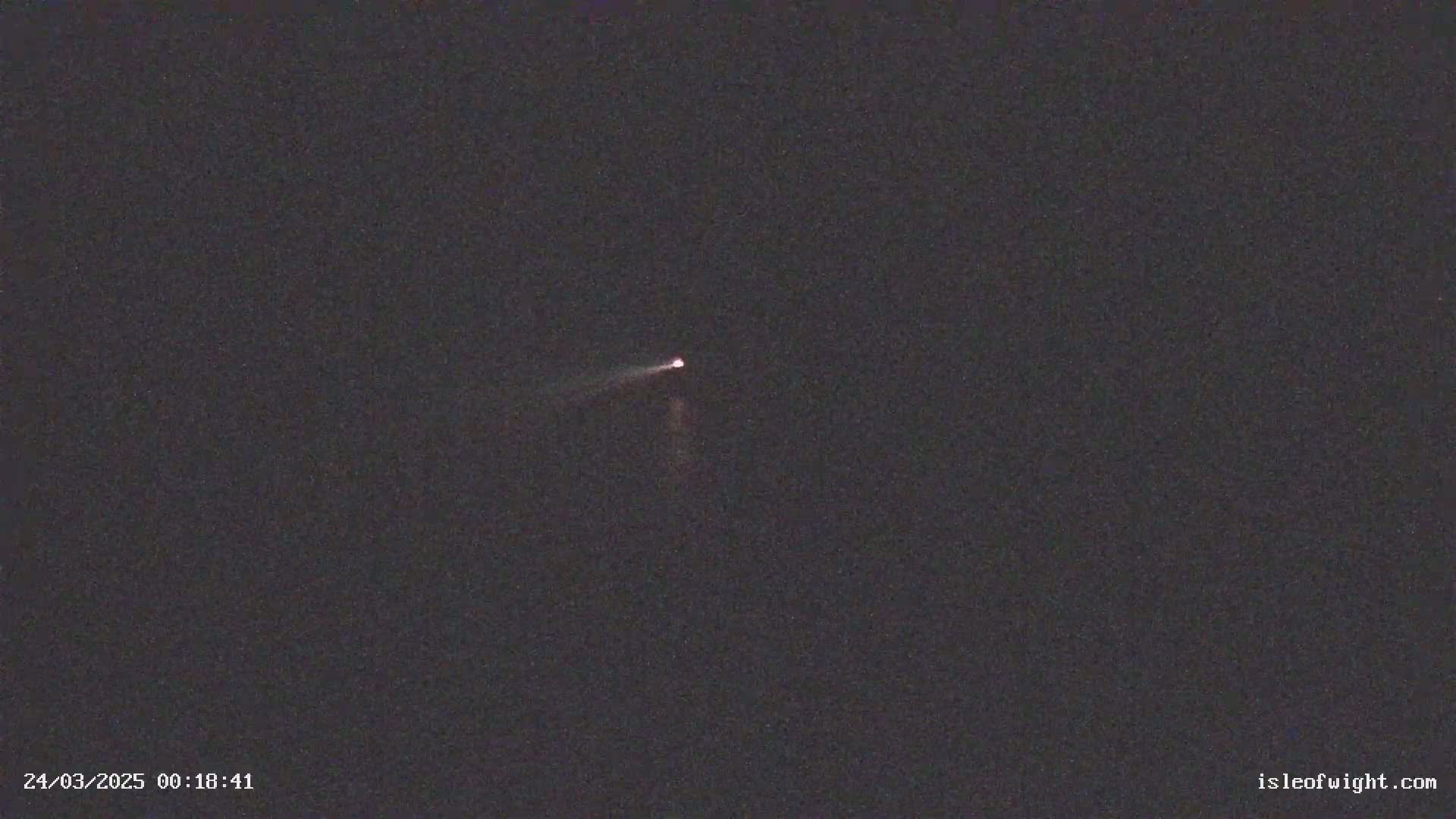 A faint, streaking light is visible against a dark, night sky.
