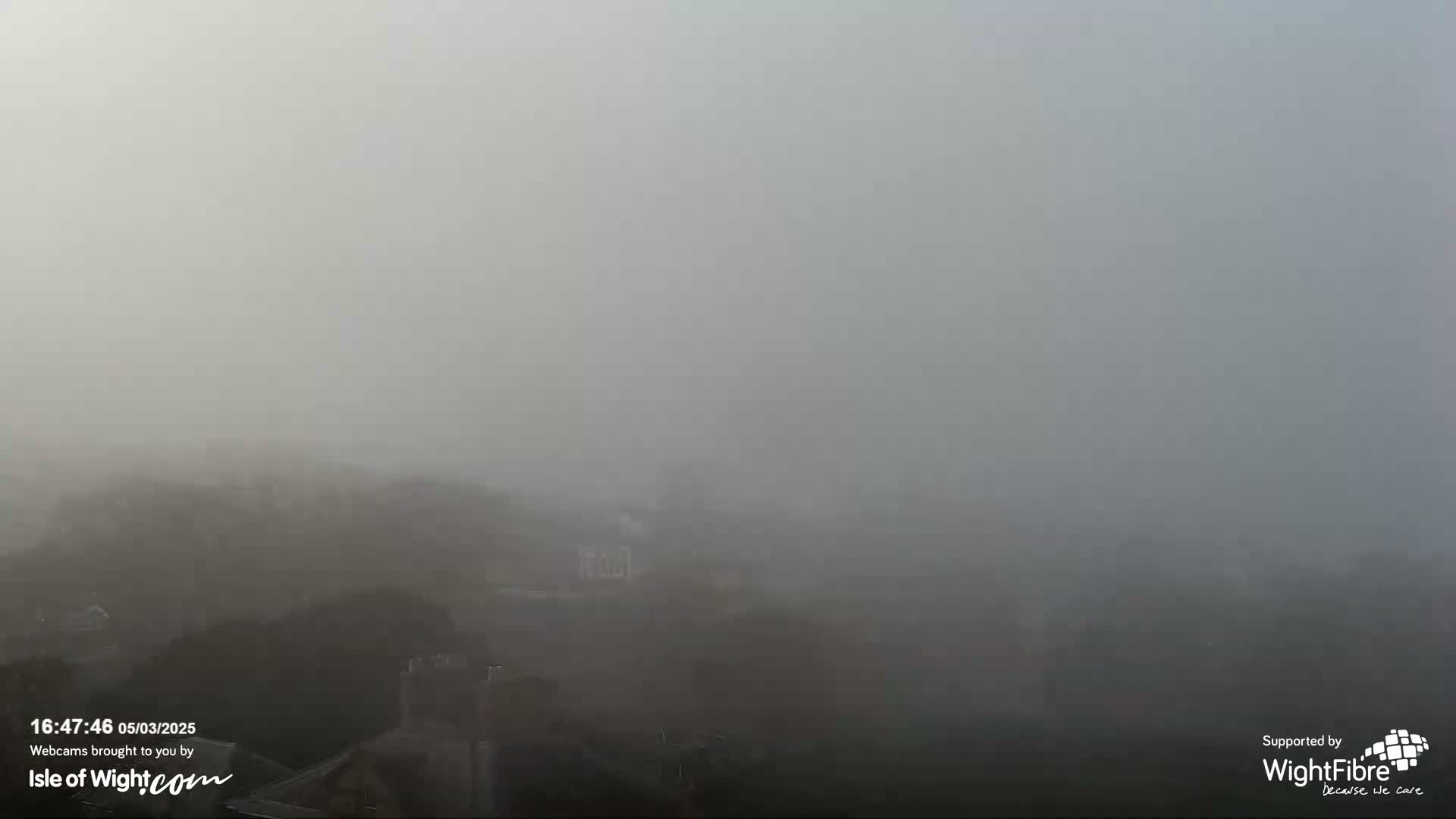 A thick fog obscures the view of a town or city.