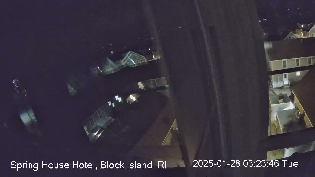 A nighttime, high-angle view shows several buildings illuminated by scattered interior lights.
