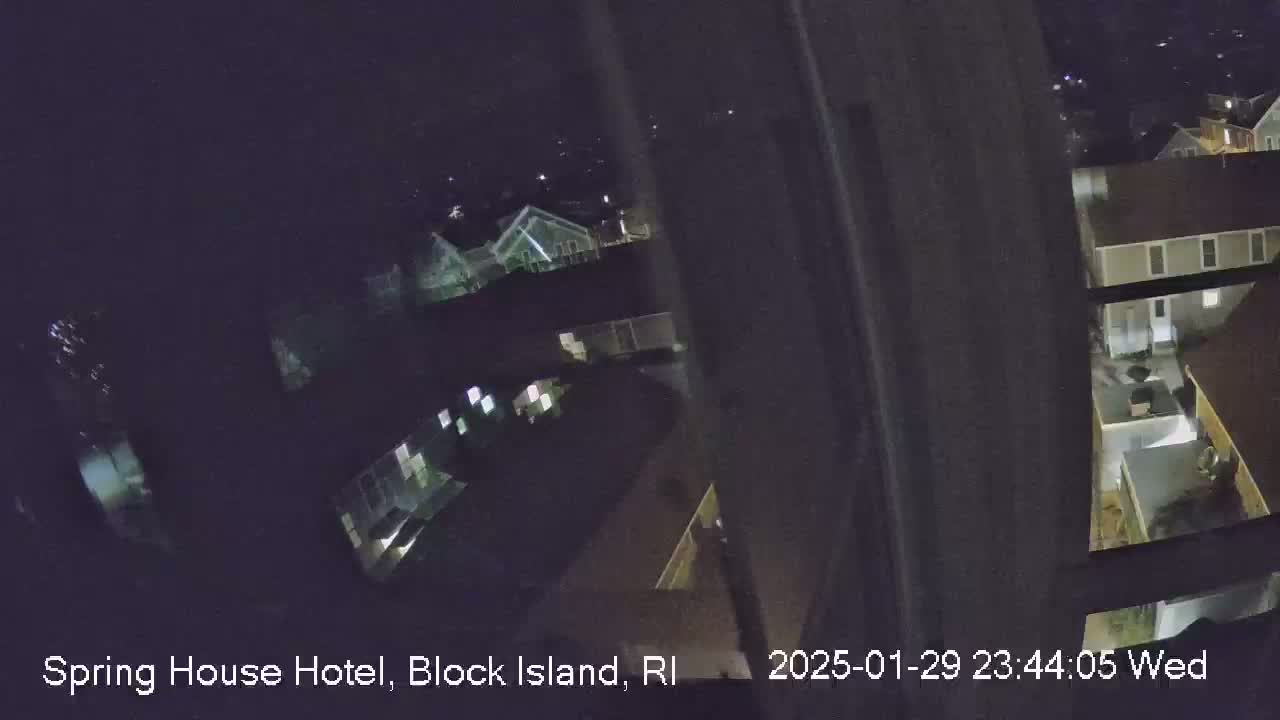 A nighttime, high-angle view shows several buildings illuminated by interior lights.