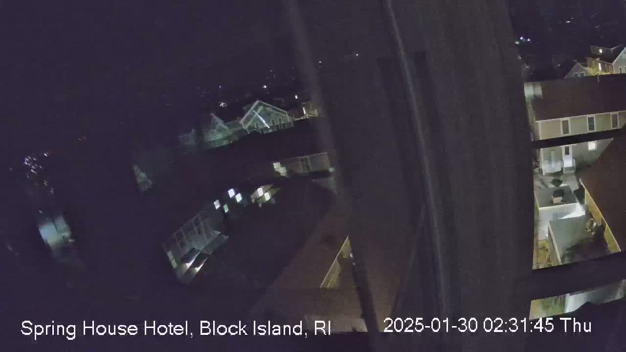 A nighttime, high-angle view shows several buildings with illuminated windows.