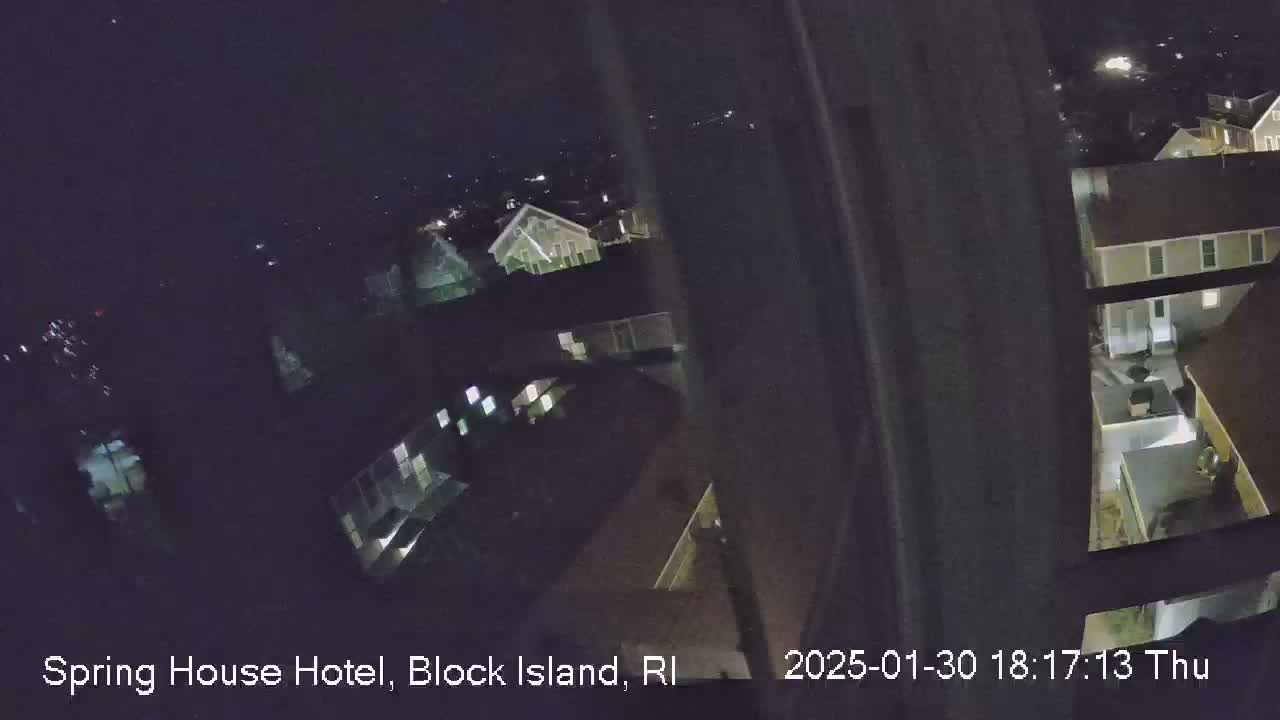 A nighttime, high-angle view shows several buildings with dimly lit windows.