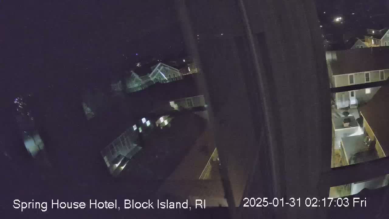 A nighttime, high-angle view shows a cluster of buildings illuminated by exterior lights.