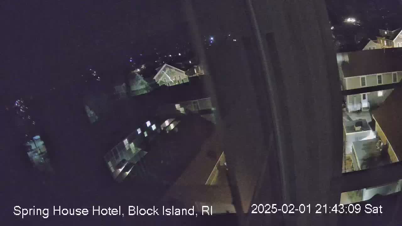 A nighttime, high-angle view shows several buildings illuminated, with a clear sky visible above.