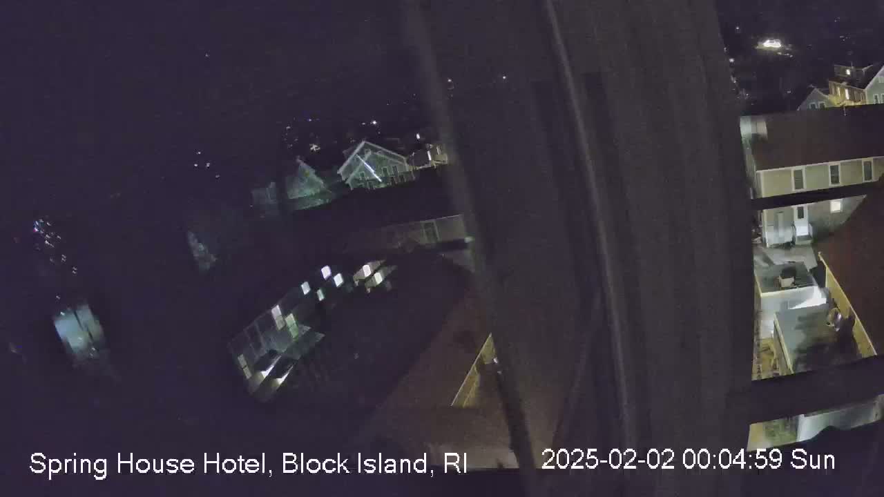 A nighttime, high-angle view shows several buildings with illuminated windows.
