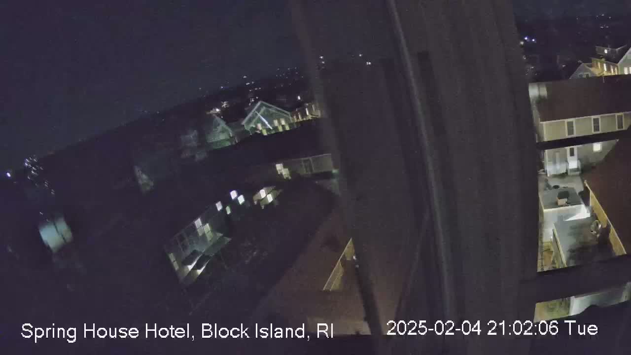 A nighttime, high-angle view shows a cluster of buildings, possibly a hotel complex, under a dark sky.