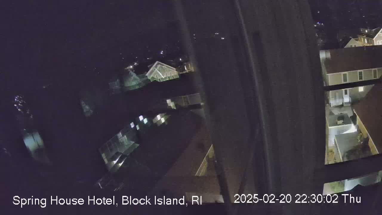 A nighttime, high-angle view shows several buildings illuminated by artificial lights.