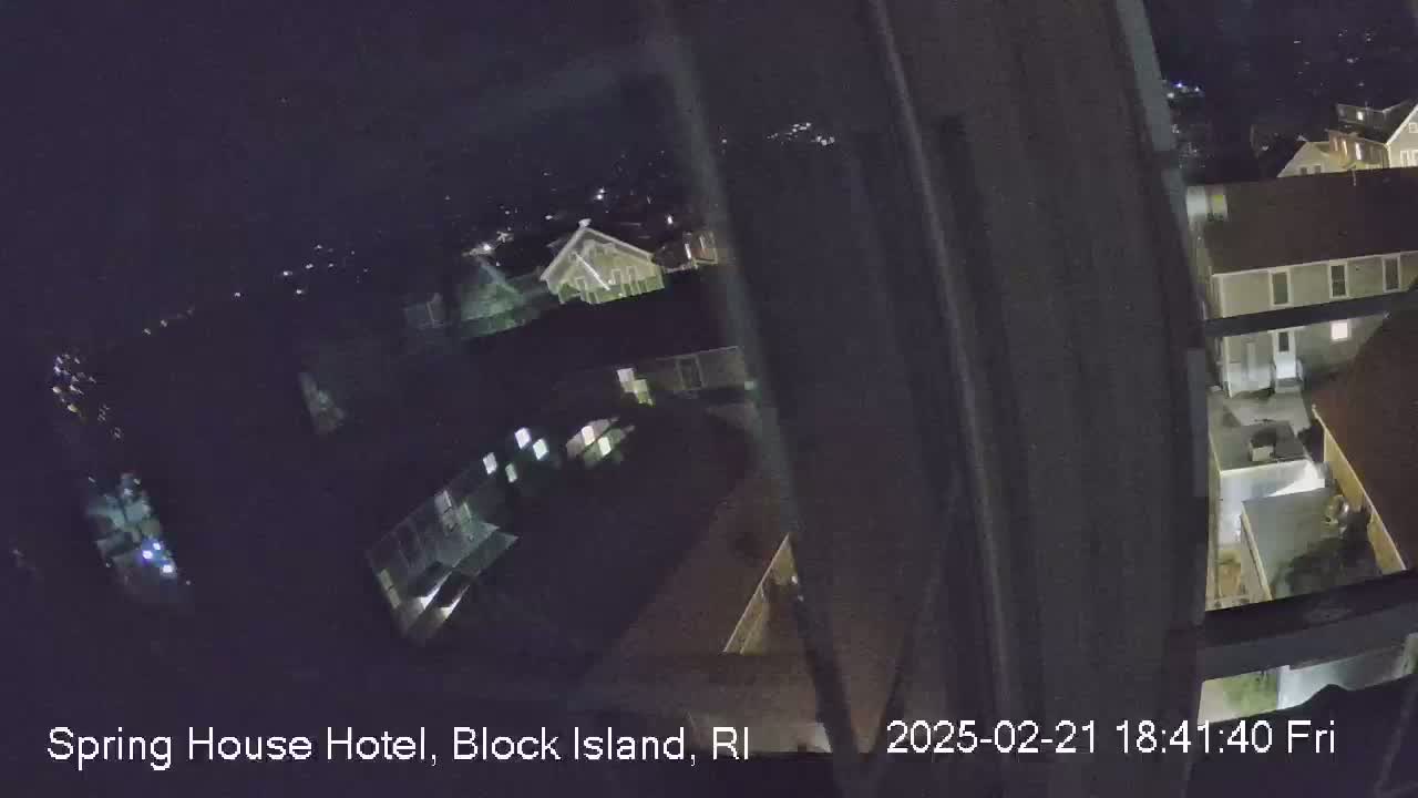 A nighttime, high-angle view shows a cluster of buildings illuminated by interior lights.