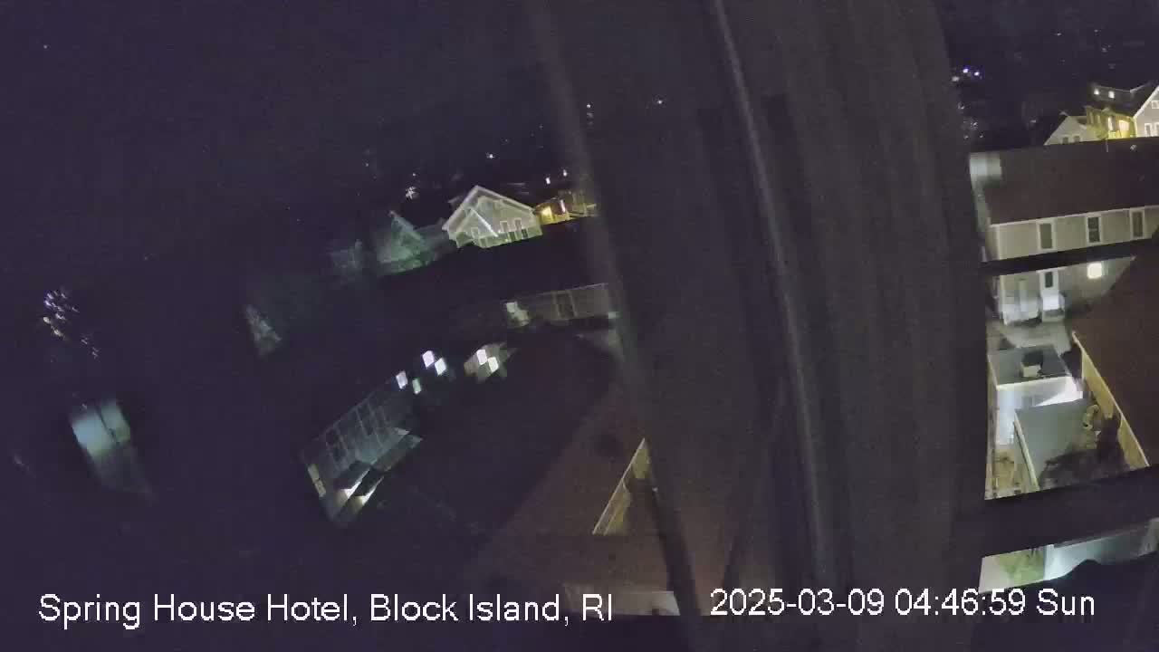 A nighttime, high-angle view shows a collection of buildings illuminated by artificial light.