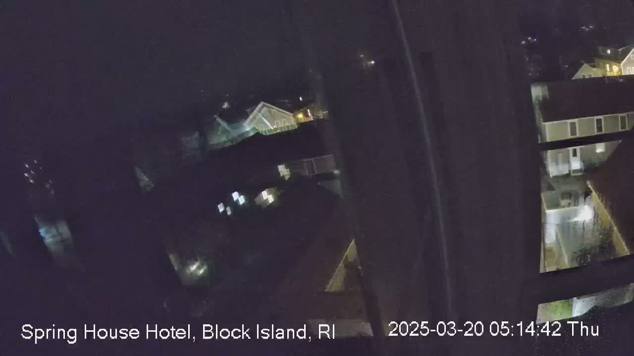 A nighttime, high-angle view shows several buildings with illuminated windows.