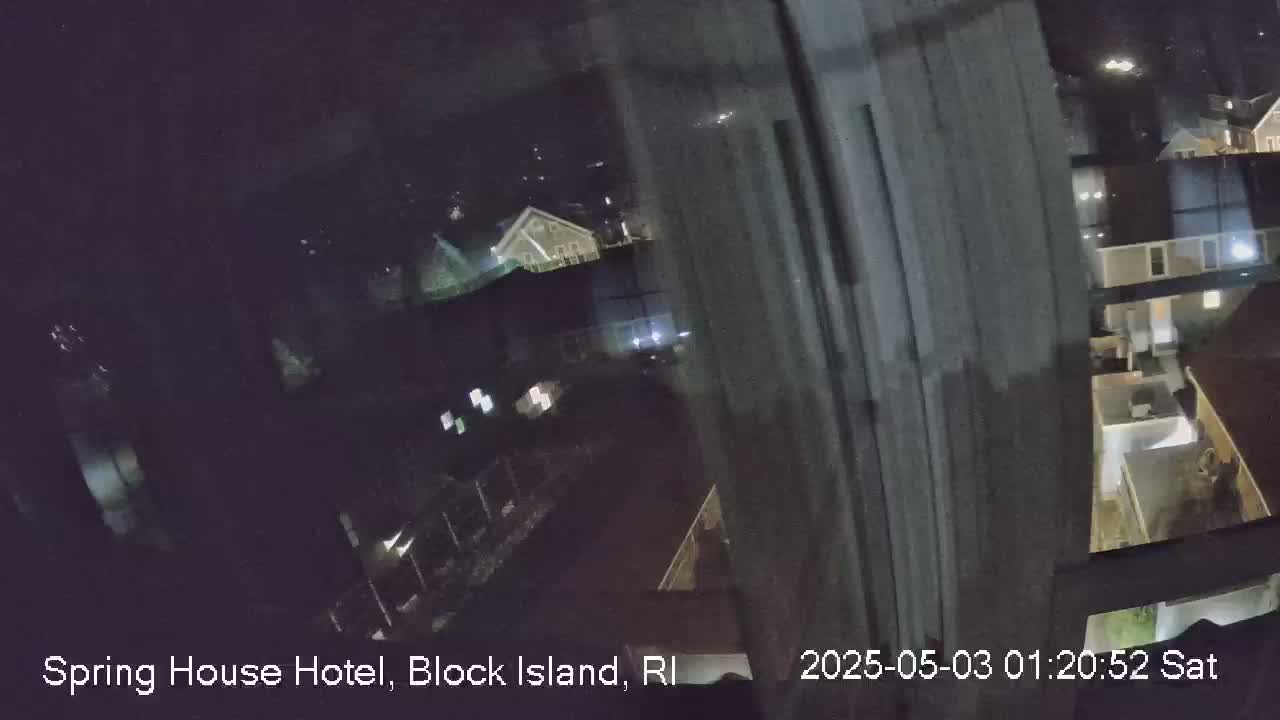 A nighttime view from a window shows a dimly lit residential area.