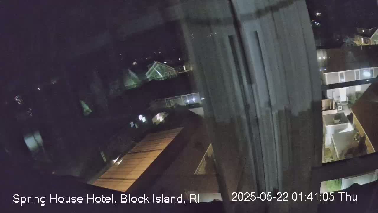 A nighttime view from a window shows a dimly lit residential area.