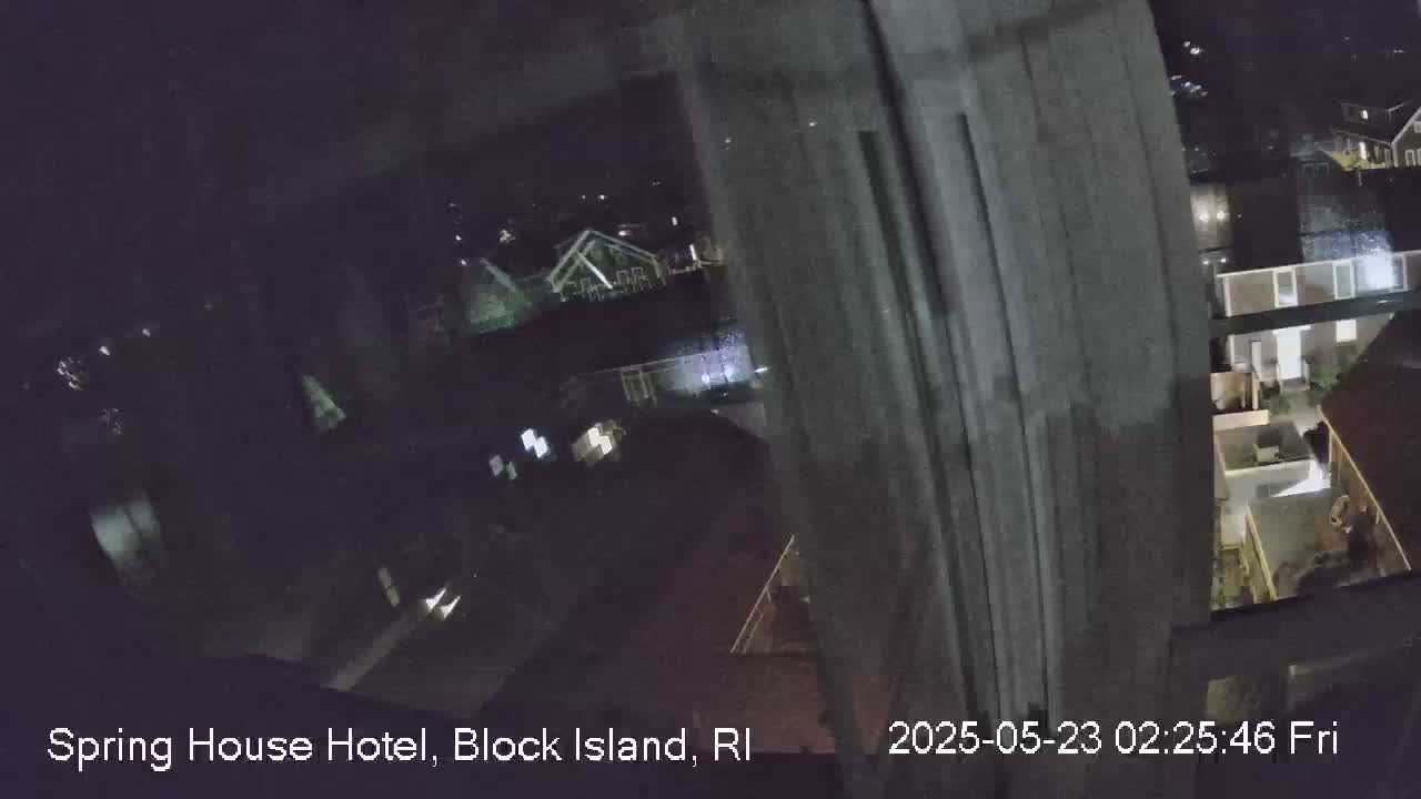 A nighttime view through a window shows a dimly lit residential area.