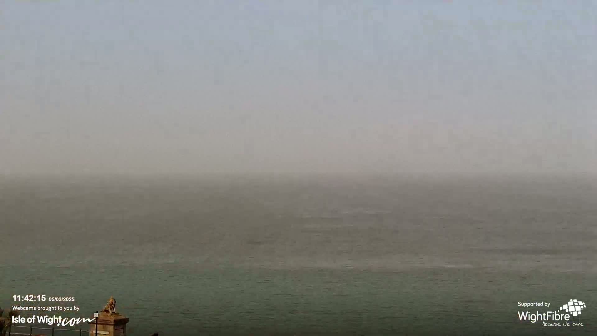 A hazy, overcast day shows a body of water stretching to the horizon.