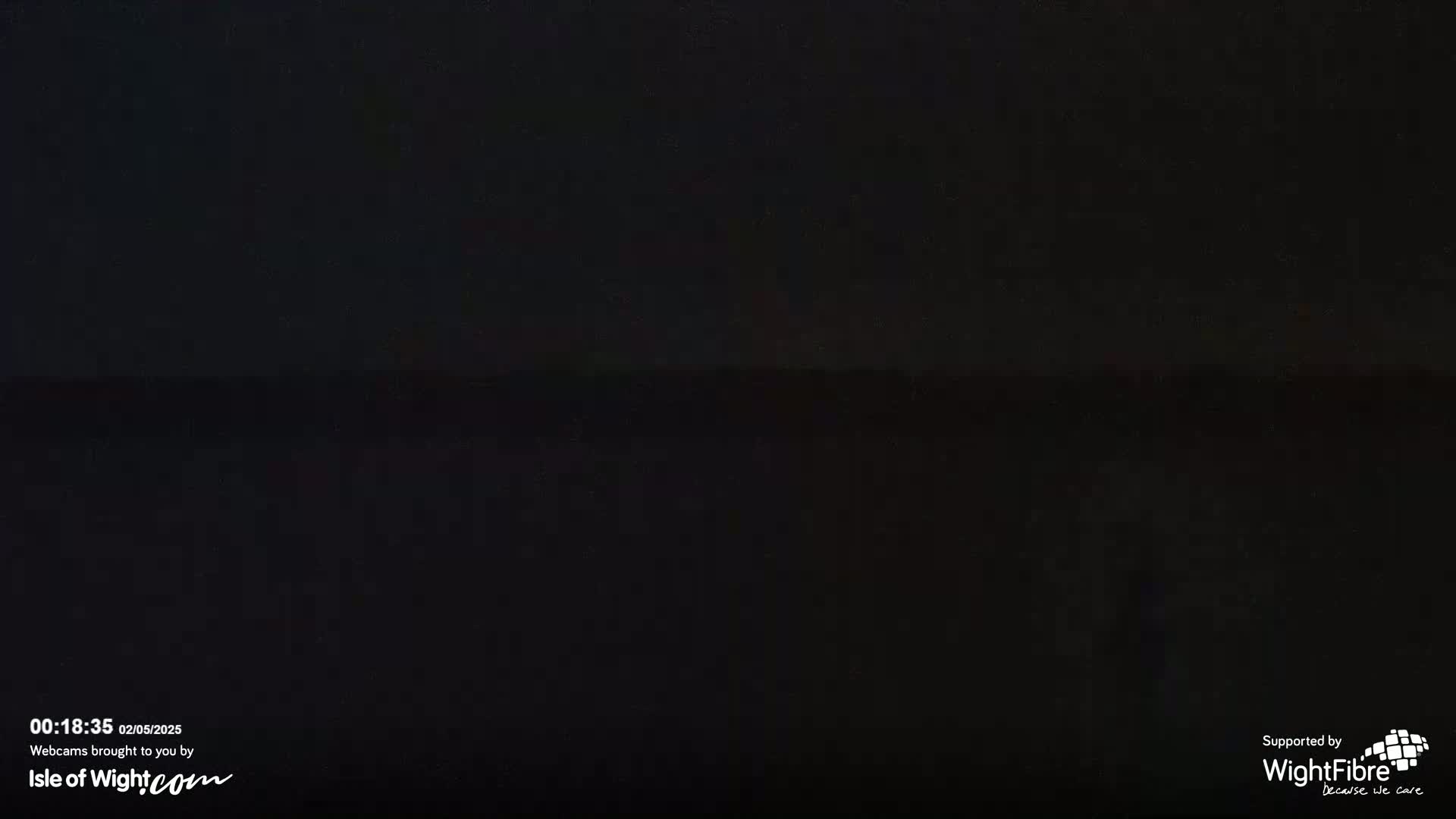 A dark, nighttime image shows a mostly black horizon line, possibly of land and sea.