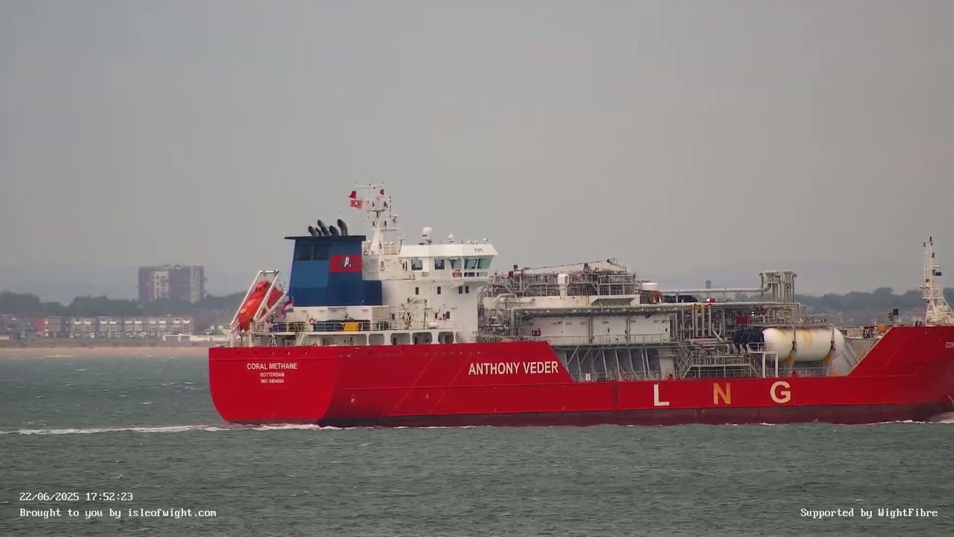 A red and white LNG tanker, the Anthony Veder, sails on a calm, gray day.