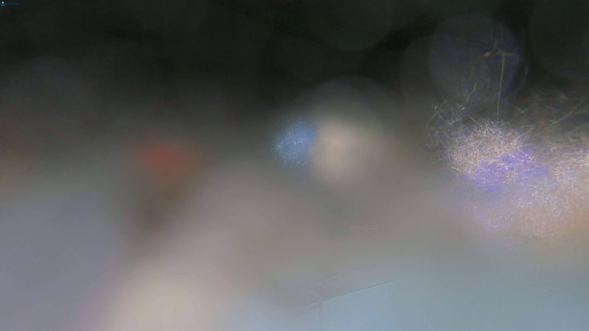 A blurry image shows out-of-focus shapes and colors suggesting an interior scene viewed through a foggy or dusty lens.