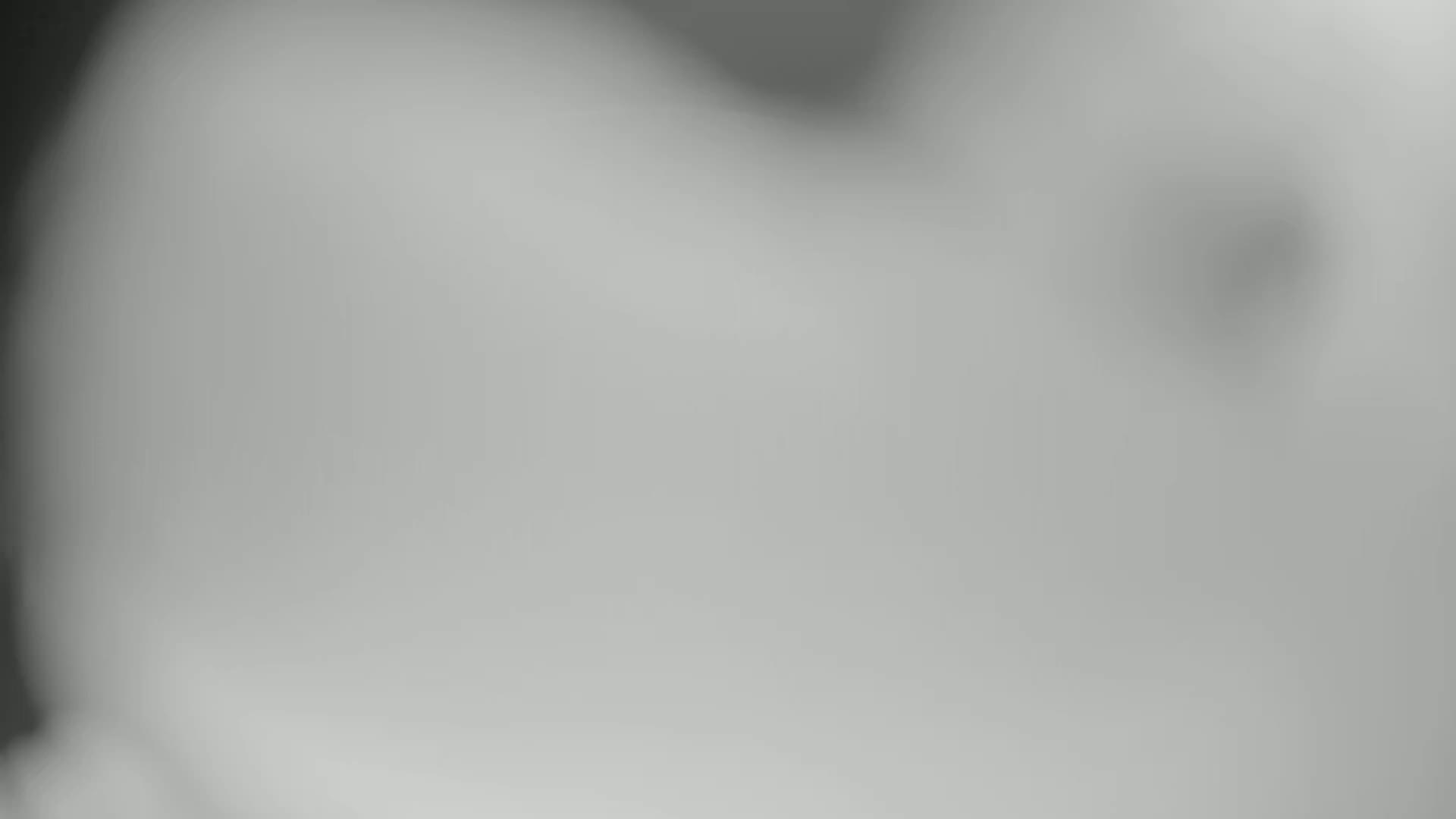 A blurry, out-of-focus grayscale image shows a hazy or foggy indistinct form.