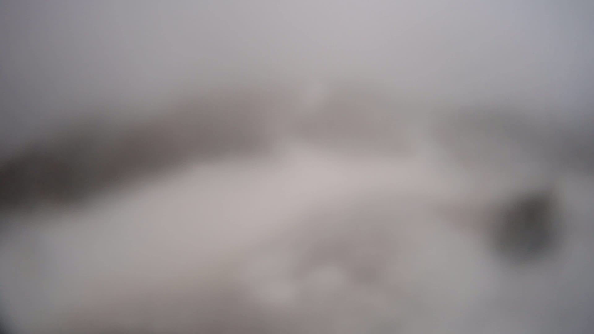 A blurry, out-of-focus image shows a landscape obscured by heavy fog or mist.
