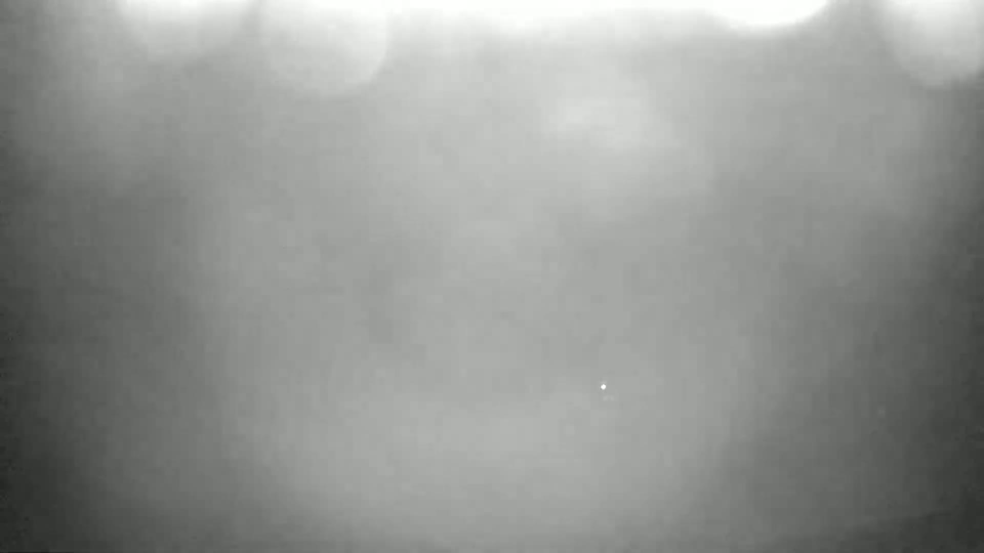 A very blurry, mostly gray image shows an indistinct scene obscured by heavy fog or mist.