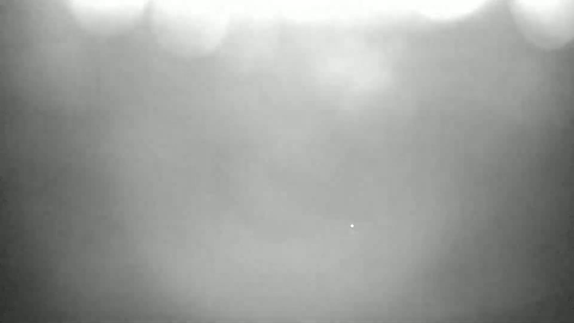 A blurry, gray image shows a hazy, overcast sky.