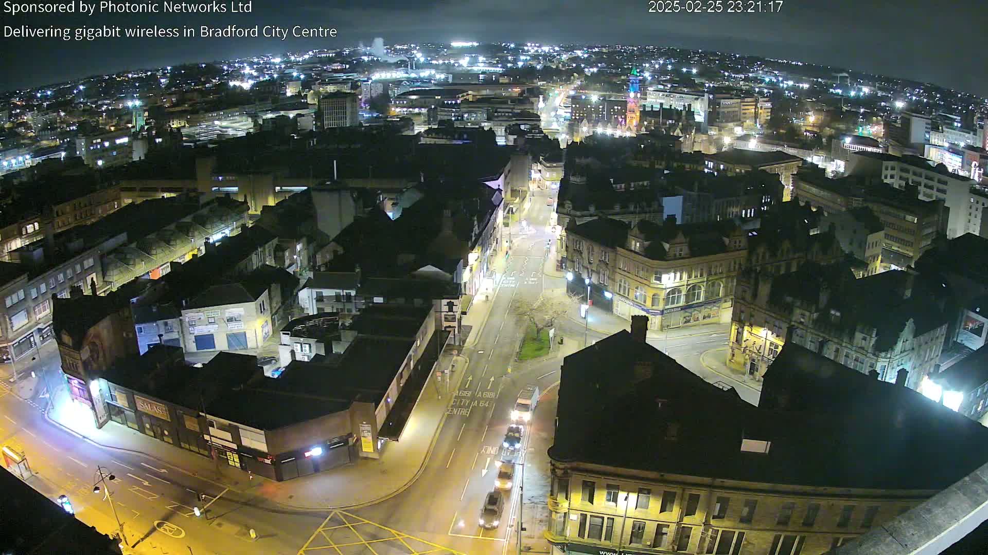A nighttime aerial view of a city's illuminated streets and buildings.