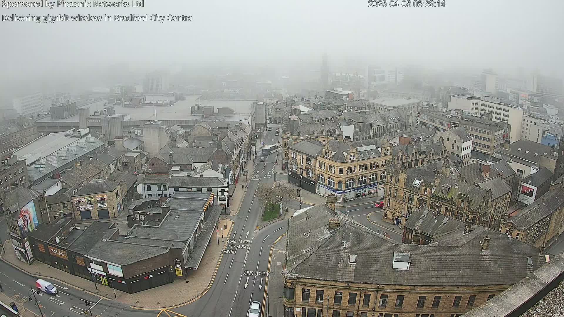 A foggy aerial view shows a city center with many stone buildings and streets.