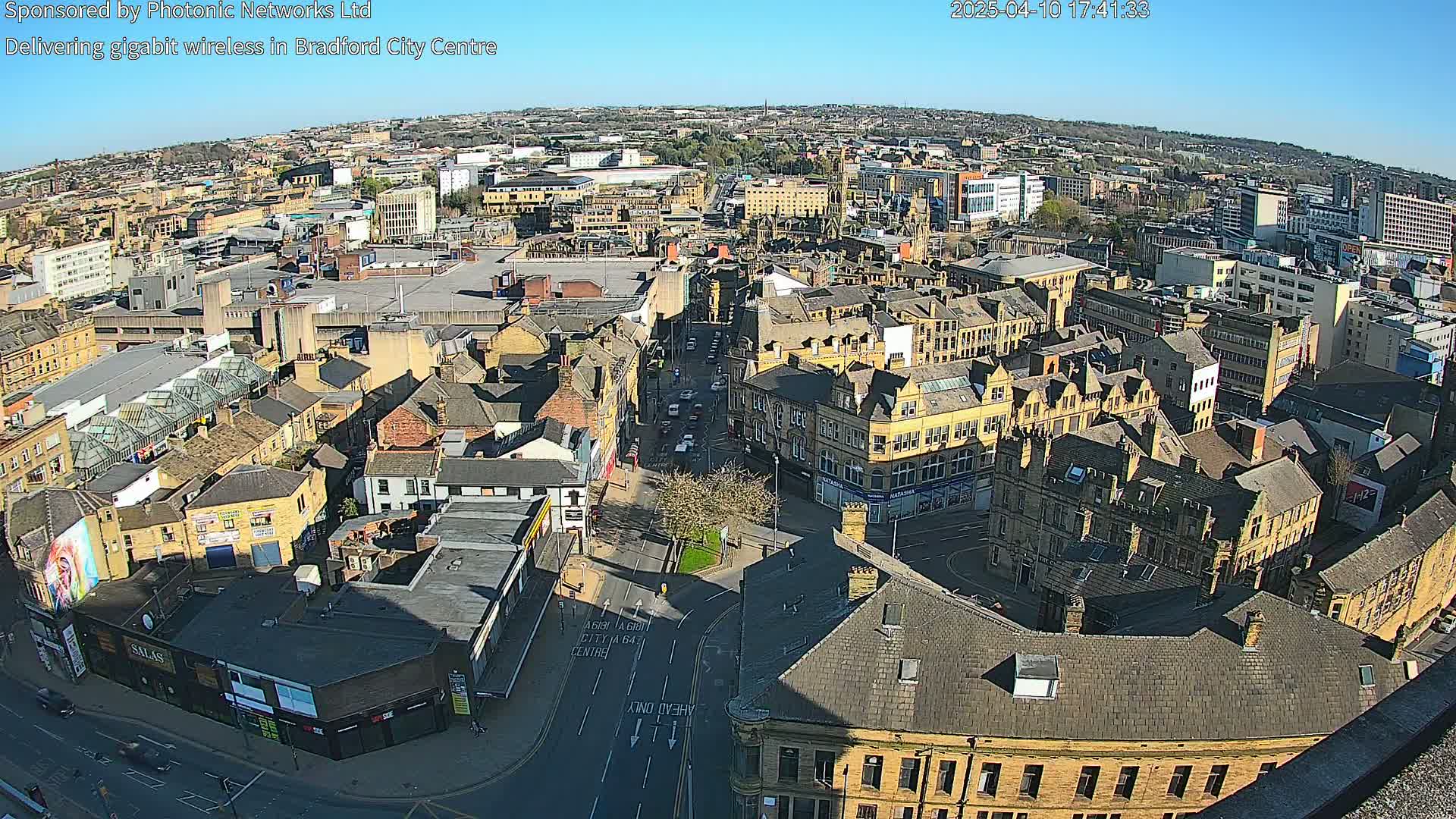 A high-angle, long shot of a city center on a sunny day, showing numerous buildings and streets.
