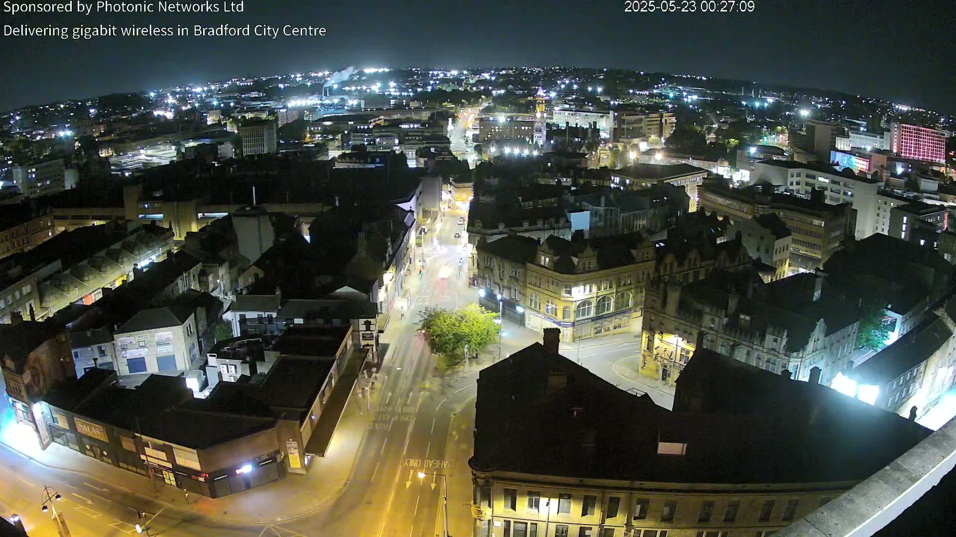 A nighttime, high-angle view of a city center with illuminated streets and buildings.