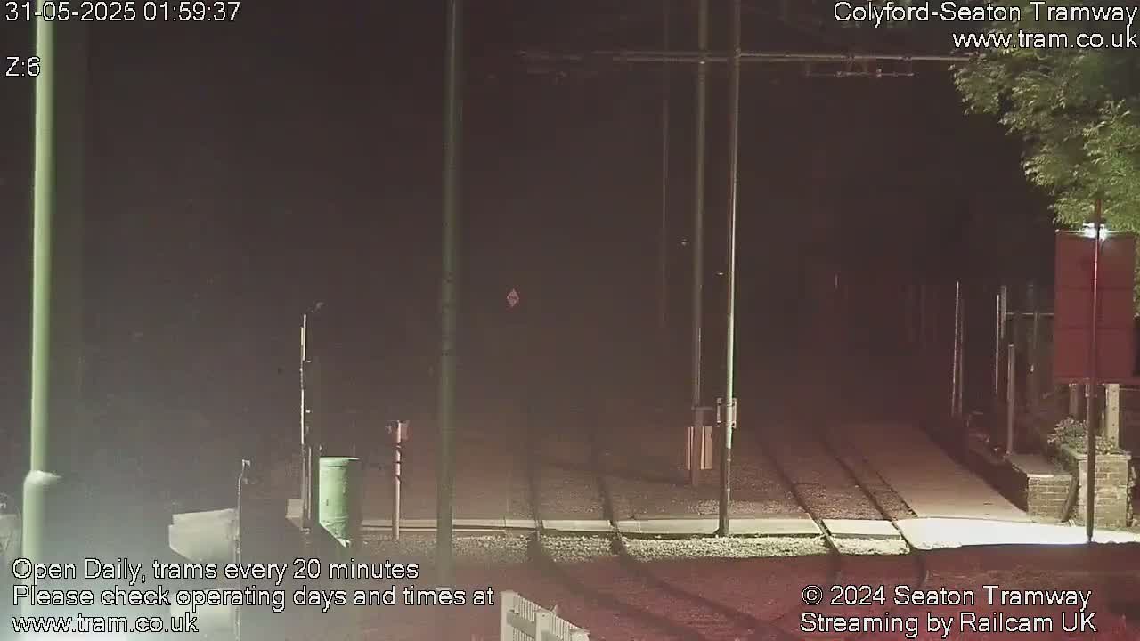 A nighttime view of empty tram tracks under a dark sky.