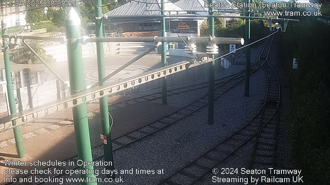 A sunny overhead view of a tram station's railway tracks and surrounding area.
