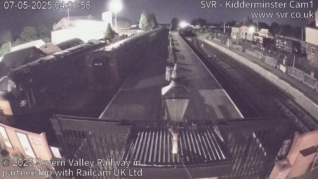 A nighttime view of a train at a station, under dark skies.