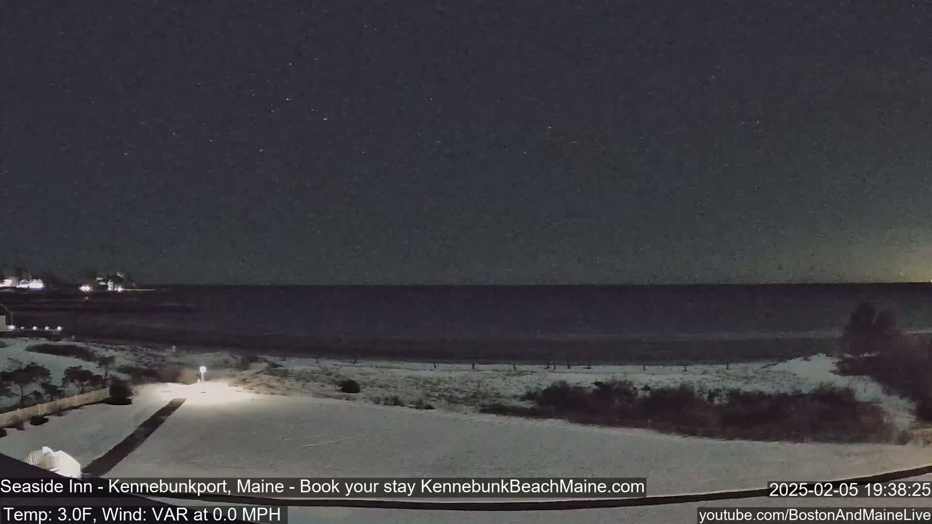 A snow-covered beach at night under a starry sky.
