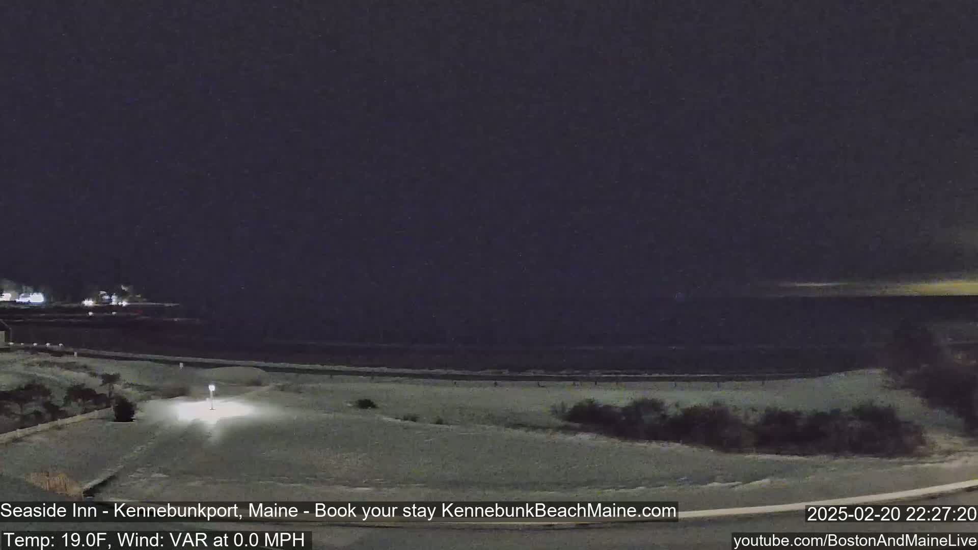 A snow-covered beach at night is seen under a dark sky.