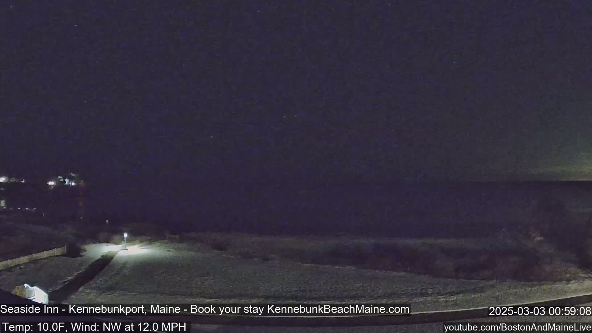 A snow-covered nighttime coastal scene shows a dark ocean under a starlit sky with a northwest wind.
