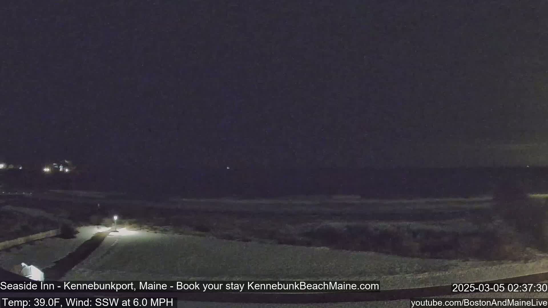 A snow-covered landscape is visible at night under a dark sky, with a faint light illuminating a path.