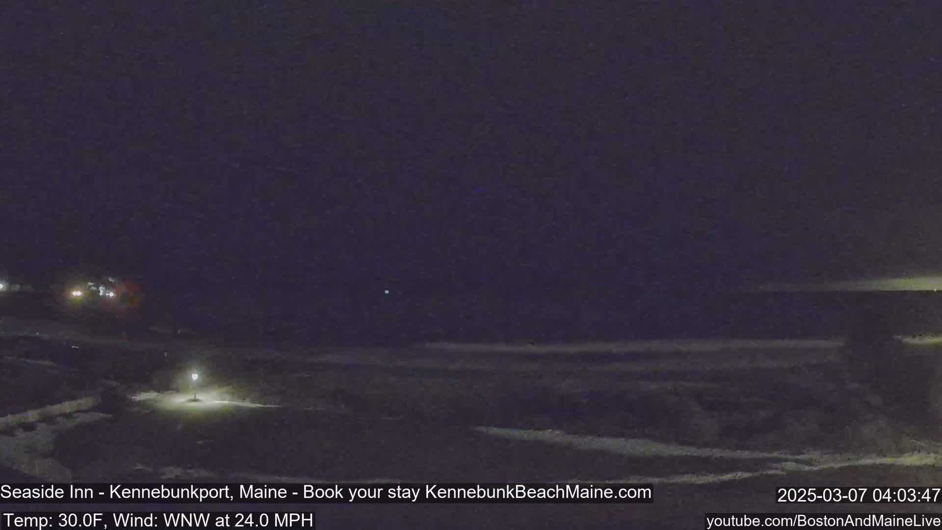 A dark nighttime scene shows a beach and ocean under a mostly clear sky, with a 30°F temperature and a 24 mph wind from the west-northwest.