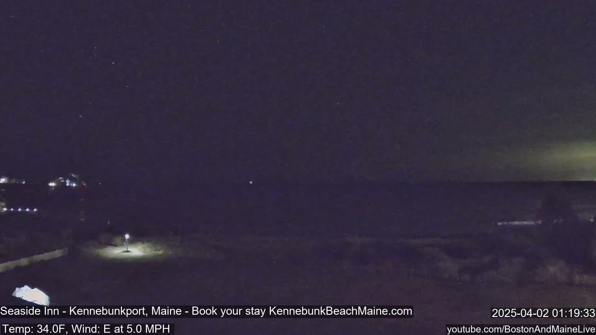 A nighttime coastal scene shows a dark ocean under a clear, starry sky with a slight easterly wind.