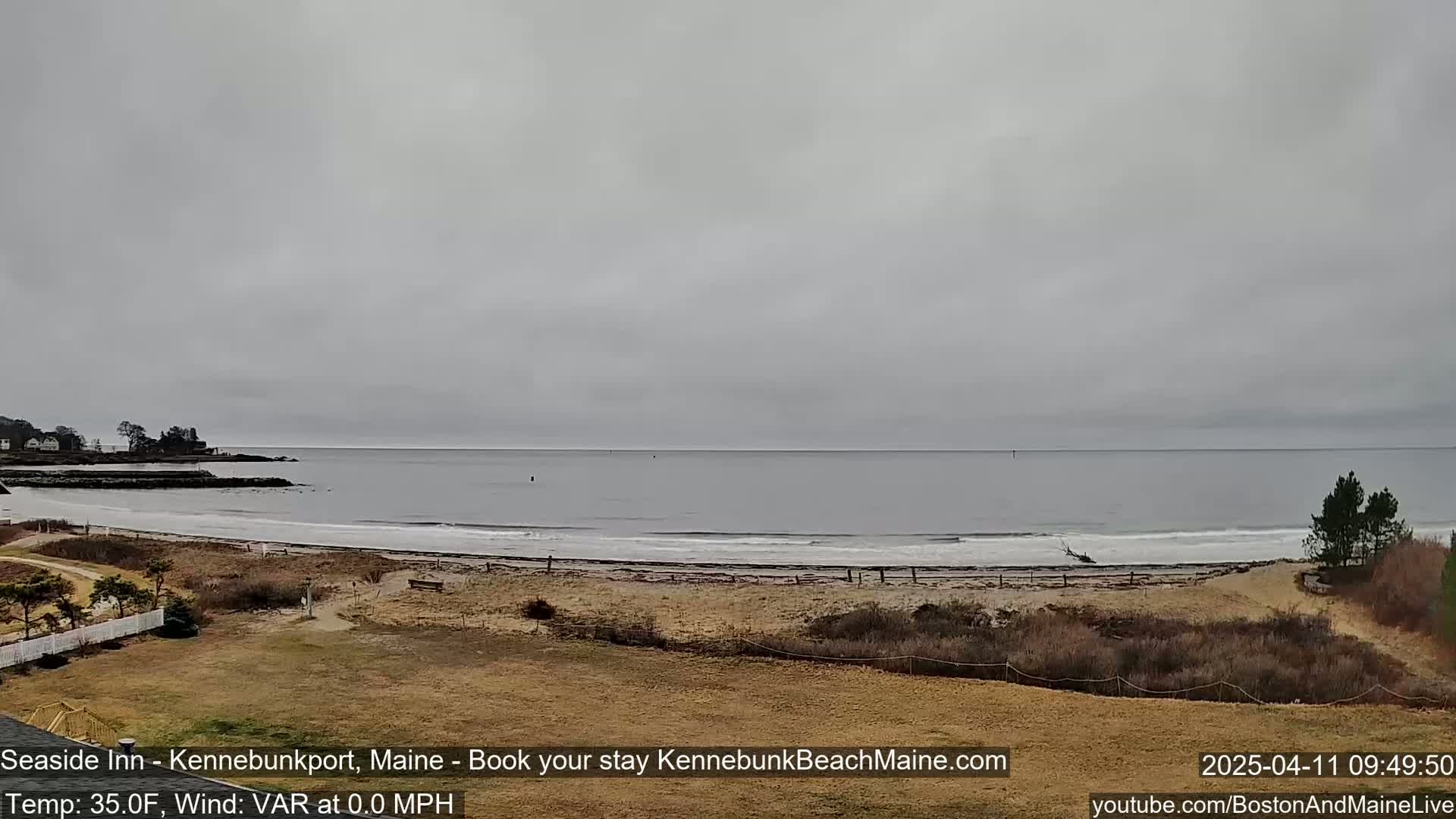 A view of a calm ocean beach under an overcast sky.