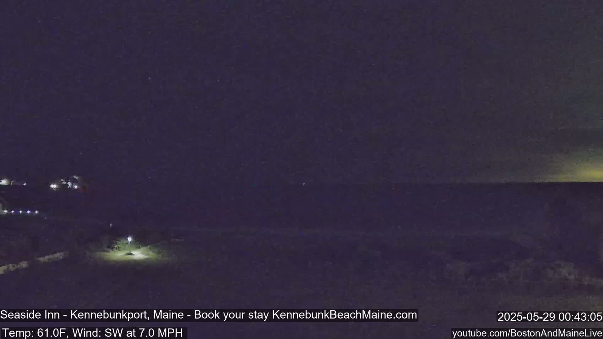 A nighttime view of a dark coastline under a mostly clear sky, with a slight southwest wind.