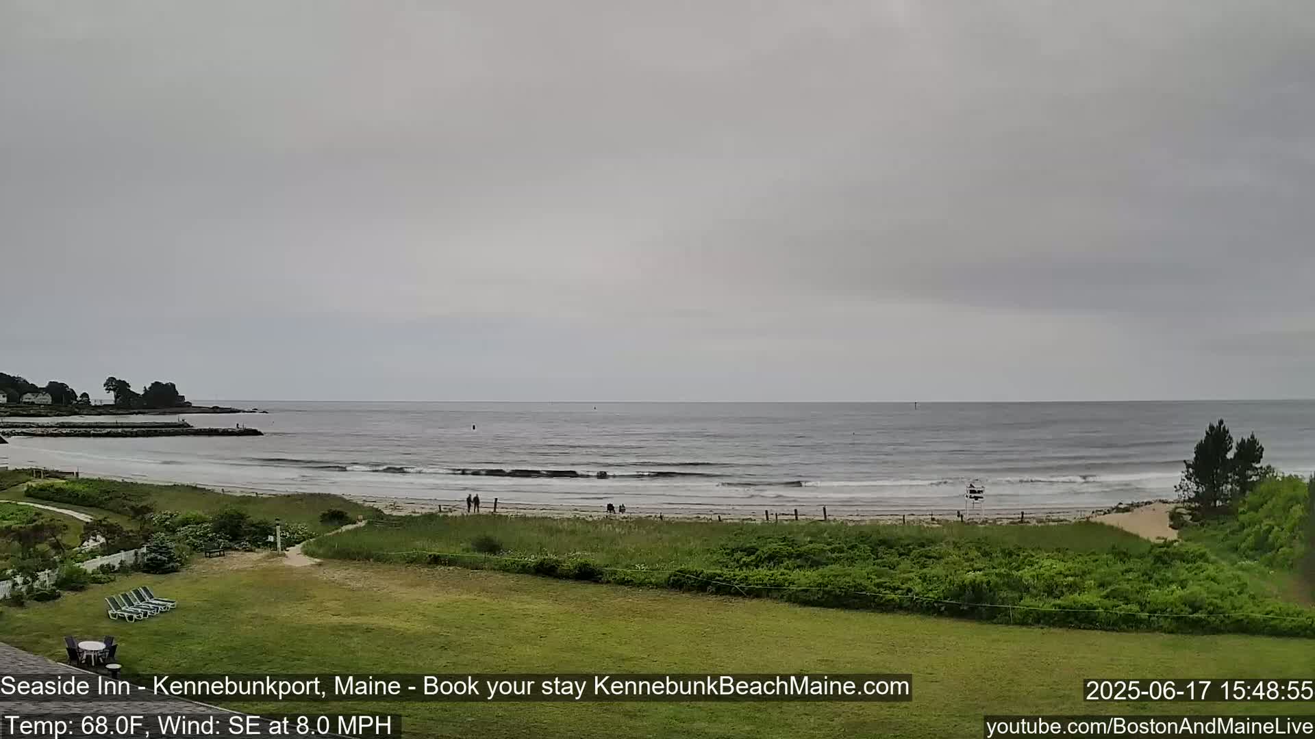 A view of a beach with a calm ocean under an overcast sky.