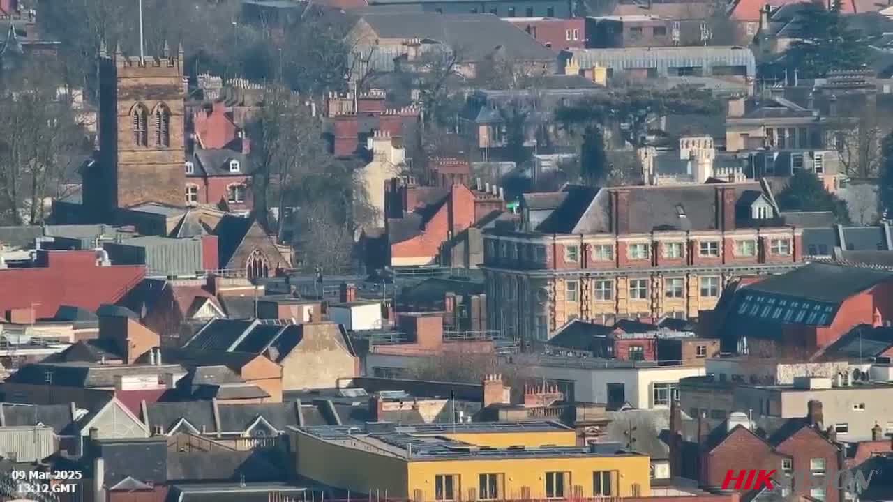 A dense collection of closely-packed buildings, many appearing to be residential, is seen on a sunny day.